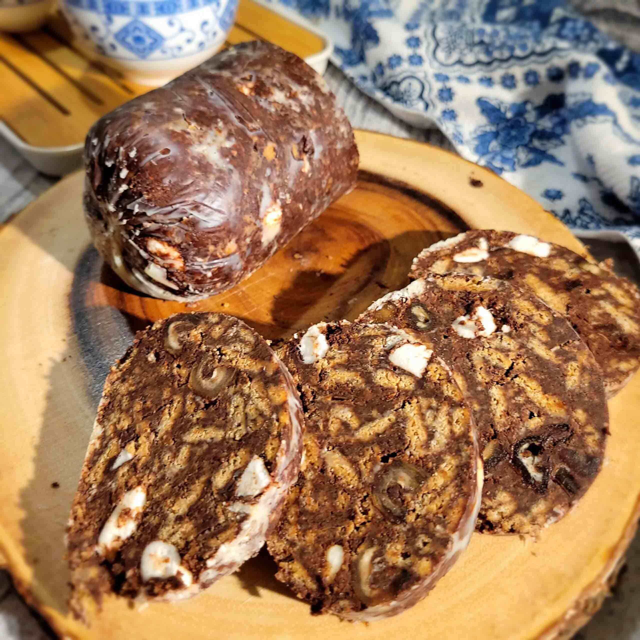 A recipe blog about Chocolate Date and Coconut Biscuit Salami using vegan honey cookies, dark chocolate, cocoa powder, roasted coconut butter, and vegan marshmallows